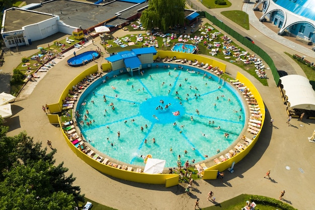 Vista superior de un lugar al aire libre para que la gente se relaje donde hay una piscina y muchas tumbonas