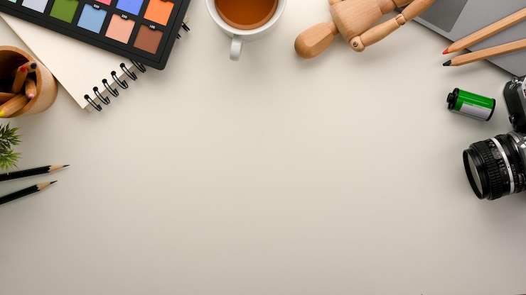 Foto vista superior del lugar de trabajo del diseñador gráfico con herramientas de trabajo esenciales y espacio de copia sobre fondo blanco.