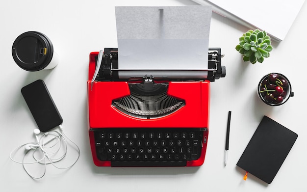 Vista superior del lugar de trabajo con máquina de escribir vintage rojo brillante