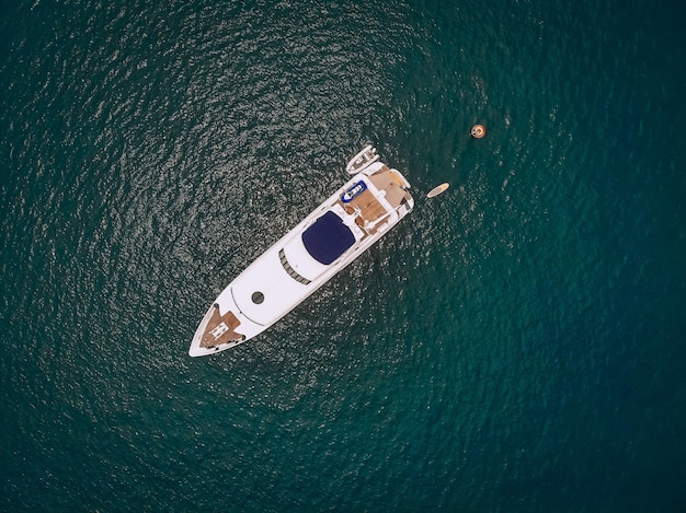 Vista superior del lujoso yate en el vasto mar azul; concepto de estilo de vida.