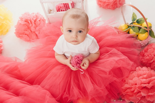 Foto vista superior: la madre de la niña sentada en vestidos rosados en el piso.