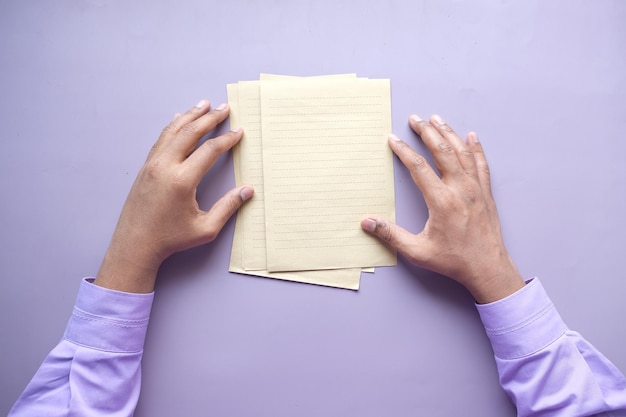 Vista superior de la mano de los hombres en papel en blanco sobre la mesa