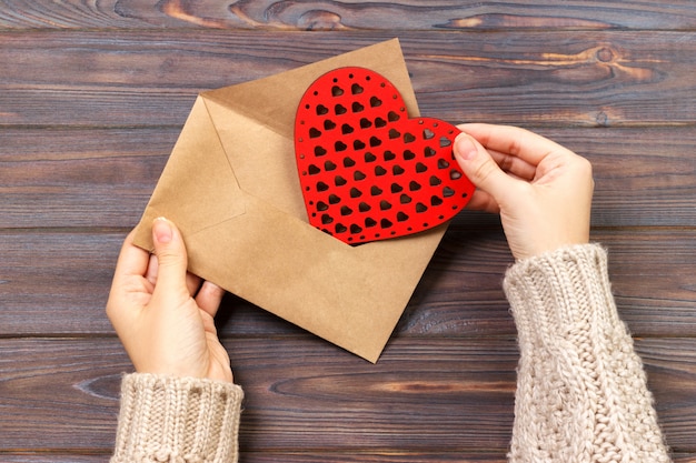 Vista superior. Mano de niña escribiendo la carta de amor el día de San Valentín.