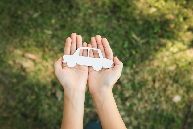 Vista superior con la mano sosteniendo el icono del coche ev simboliza el giro comercial ecológico