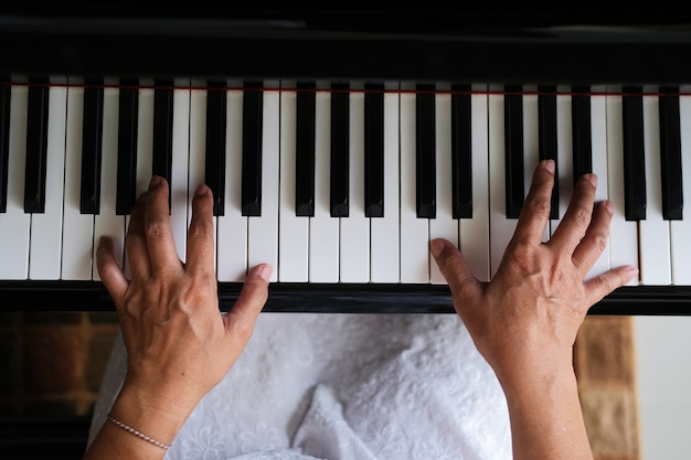 Vista superior de la mano tocando un piano