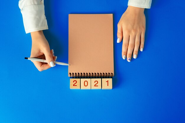 Vista superior de manos femeninas escribiendo en el cuaderno