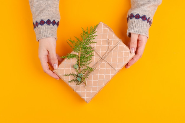 Vista superior de manos de mujer con caja de regalo