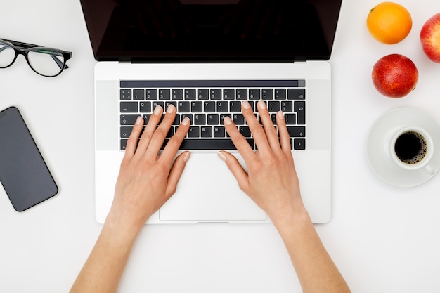 Vista superior de manos de mujer hermosa usando laptop