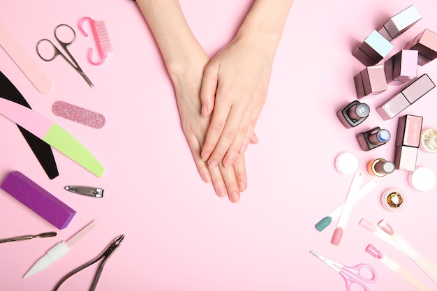 Vista superior de las manos de la mujer con herramientas profesionales para el cuidado de las uñas para manicura