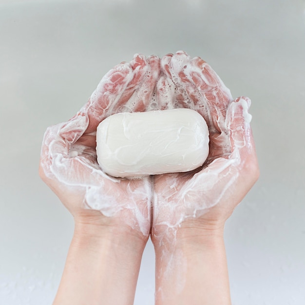 Vista superior de manos sosteniendo barra de jabón