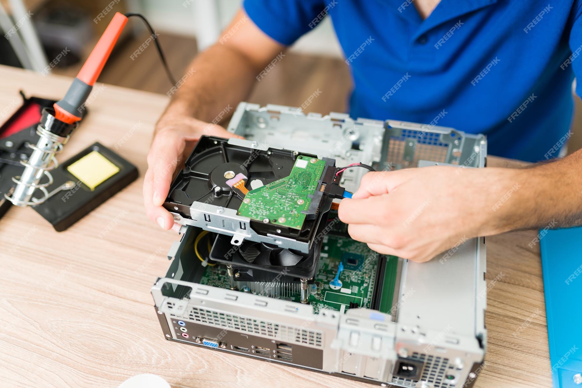 Vista superior de manos técnico conectando un duro reparado dentro de una cpu computadora en el taller | Foto Premium