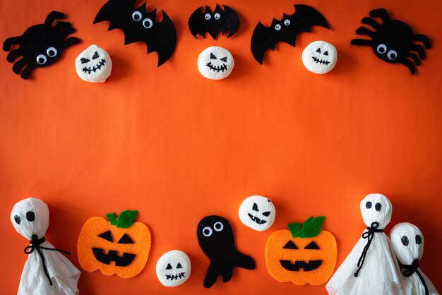 Vista superior de las manualidades de Halloween sobre fondo naranja con espacio de copia