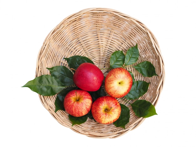 Vista superior de manzanas de frutos rojos en cestas de bambú y hojas verdes aisladas en espacio en blanco con trazado de recorte