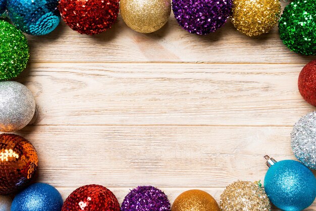 Vista superior del marco hecho de bolas decorativas sobre fondo de madera concepto de juguetes de Navidad con espacio vacío para su diseño