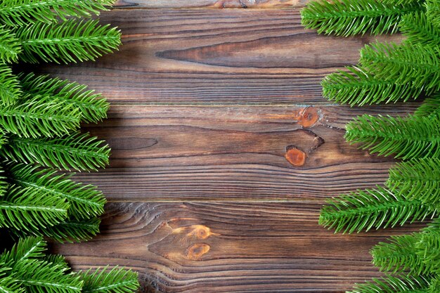 Vista superior del marco hecho de ramas de abeto en fondo de madera concepto de Navidad con espacio vacío para su diseño