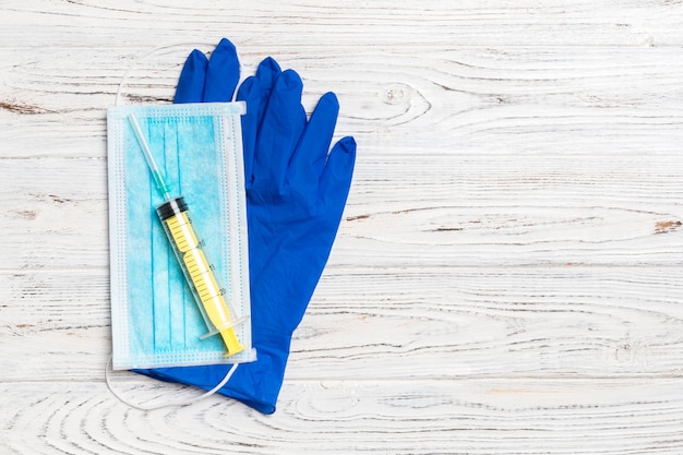 Foto vista superior de la mascarilla quirúrgica desechable par de guantes médicos de látex y jeringa