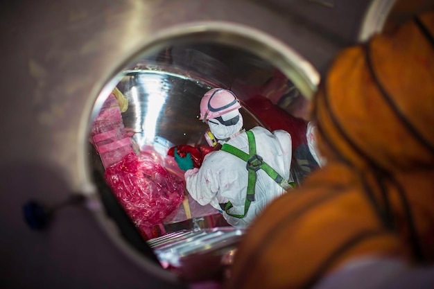 Vista superior masculina sobe as escadas para a área química do tanque de segurança do espaço confinado