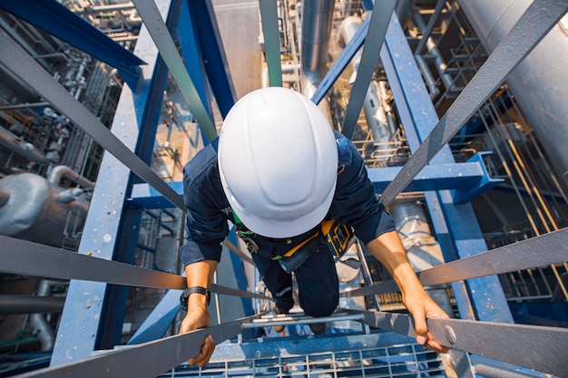 Vista superior masculina subir el aceite del tanque de inspección visual de almacenamiento de escalera