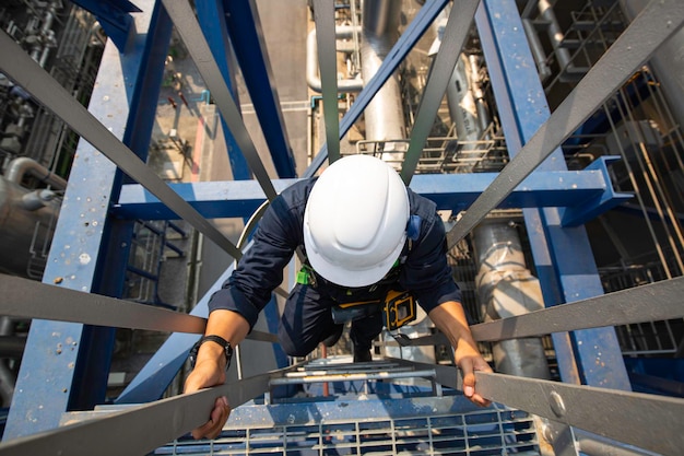 Vista superior masculina subir el aceite del tanque de inspección visual de almacenamiento de escalera