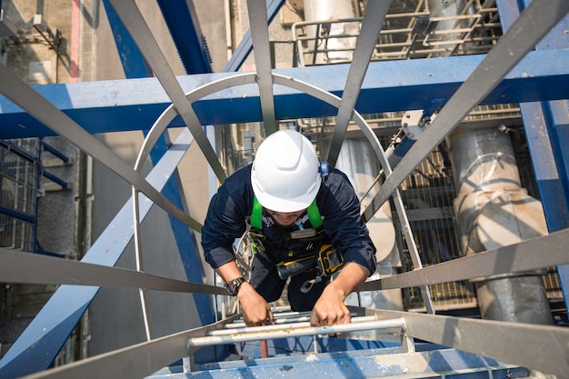 Foto vista superior masculina subir el aceite del tanque de inspección visual de almacenamiento de la escalera