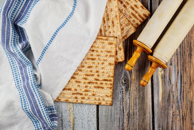 Vista superior de matzah, tallit y torah sobre fondo de madera.