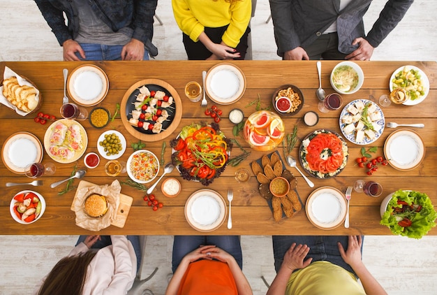 Vista superior de la mesa de cena de amigos. La gente come comida sana juntos, fiesta en casa.