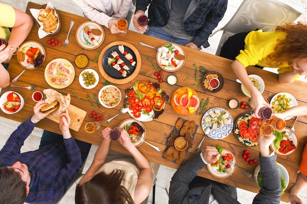 Vista superior de la mesa de cena de amigos. La gente come comida sana juntos, fiesta en casa.