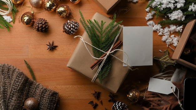 Vista superior de la mesa de madera con caja de regalo y adornos en concepto de Navidad