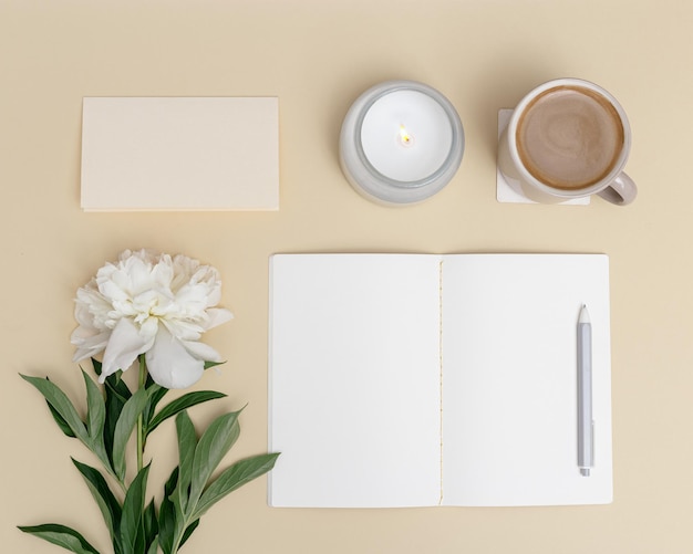 vista superior mesa de oficina escritorio Espacio de trabajo con cuaderno en blanco pluma taza de café flor de peonía blanca