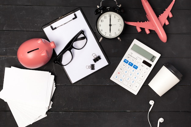 Foto vista superior de una mesa de oficina con papelería y avión rosa.