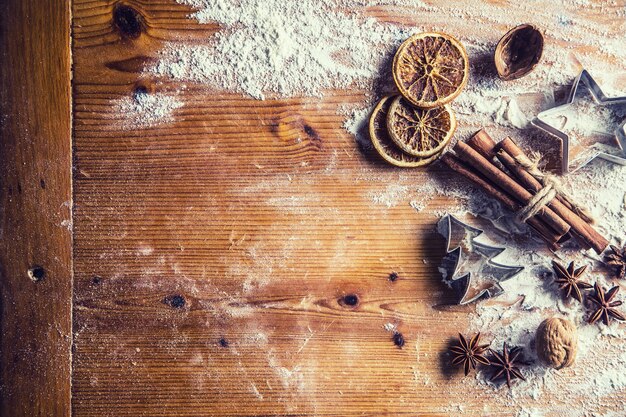 Vista superior de la mesa de panadería llena de ingredientes aromáticos navideños