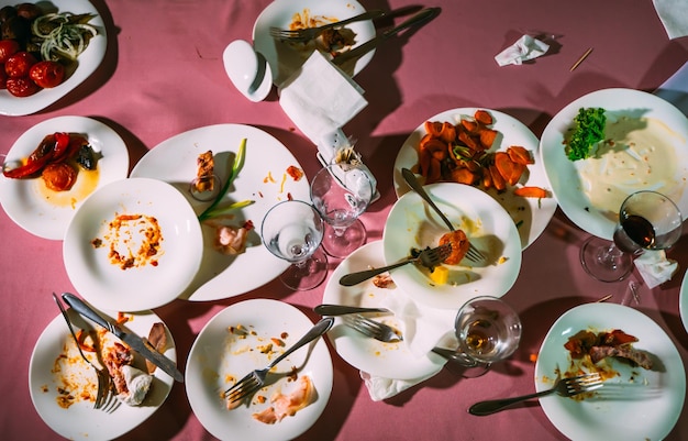 Vista superior de una mesa con platos sucios, tenedores y cuchillos después de comer en el restaurante El concepto de platos sucios desordenados