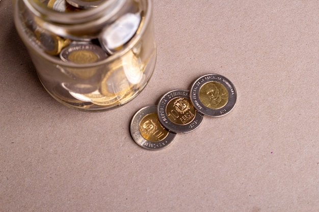 Vista superior monedas dominicanas en un frasco de vidrio, concepto financiero