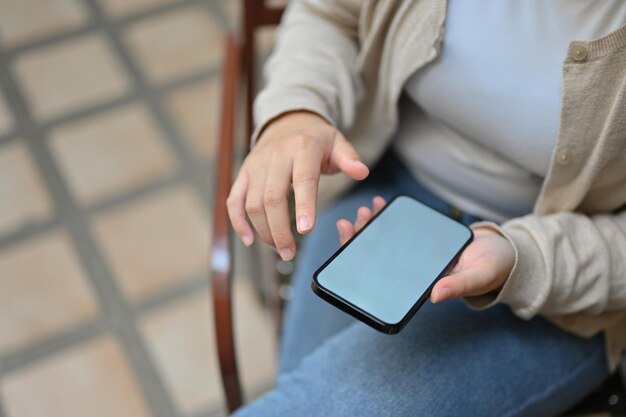 Vista superior de una mujer asiática usando su teléfono inteligente mientras se relaja al aire libre