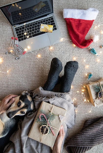 Vista superior de la mujer de compras en línea en las vacaciones de Navidad con la computadora portátil y la tarjeta de crédito