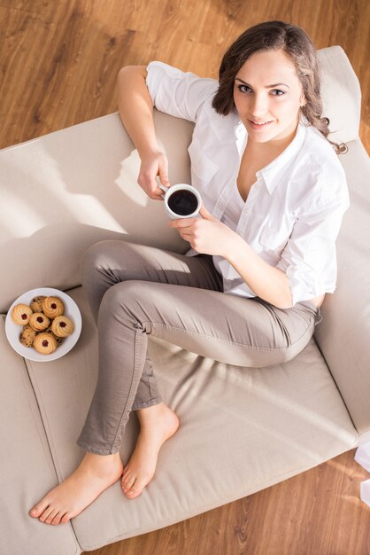 Vista superior de una mujer joven con una taza de café.