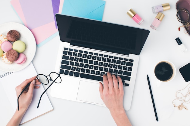 Vista superior de la mujer que usa la computadora portátil en el lugar de trabajo femenino