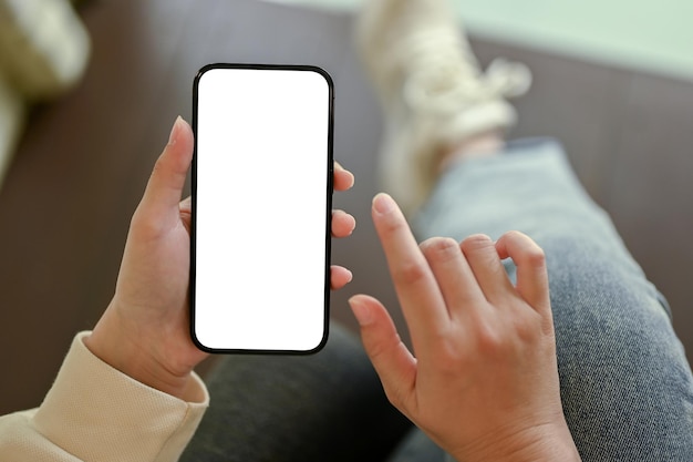 Vista superior de una mujer usando su maqueta de pantalla blanca de teléfono inteligente