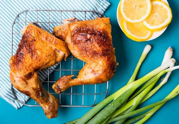 Vista superior de muslos de pollo con rodajas de limón y cebolla verde