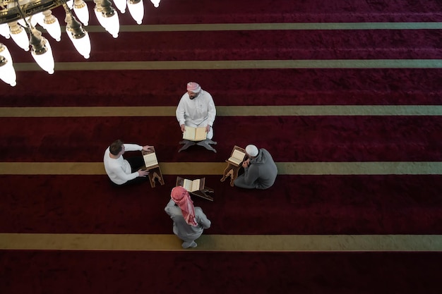 vista superior de los musulmanes en la mezquita leyendo el Corán juntos concepto de educación islámica y escuela del libro sagrado kuran