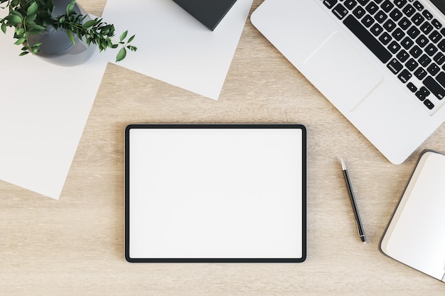 Vista superior na tela do tablet digital branco em branco com moldura preta na superfície da mesa de madeira com planta verde portátil e folhas de papel renderização em 3D mock up