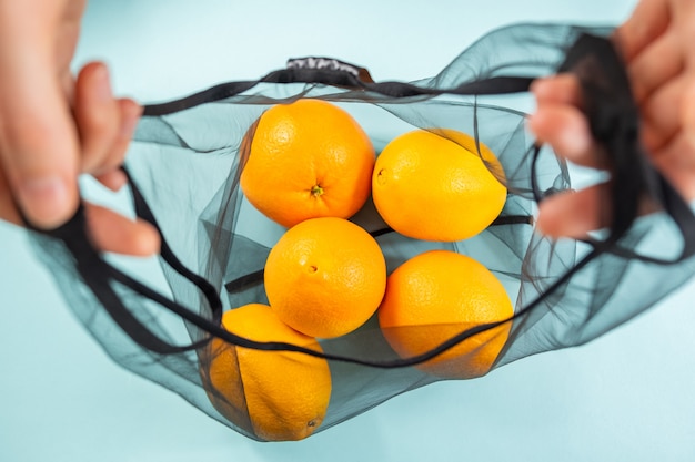 Vista superior de naranjas en una bolsa reutilizable.