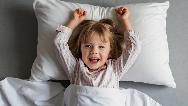 Foto vista superior de una niña alegre con cabello rubio y ojos azules con pijama despojada.