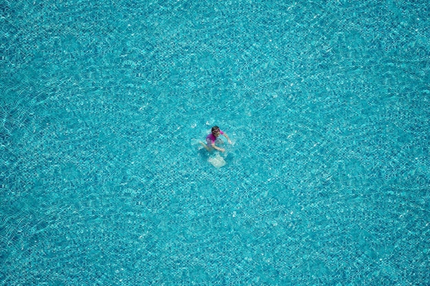 Vista superior de niña nadando en la piscina