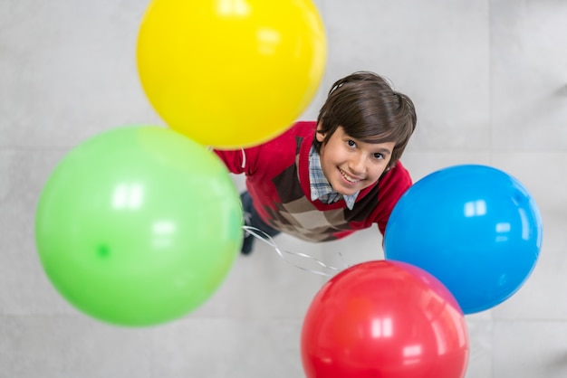 Foto vista superior de niño con globos