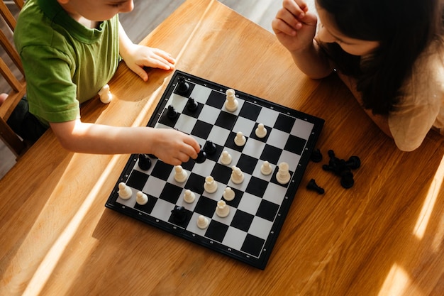 Vista superior niño y niña jugando al ajedrez