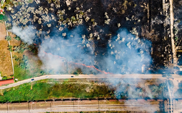 Vista superior no início do incêndio em um campo gramado perto da estrada