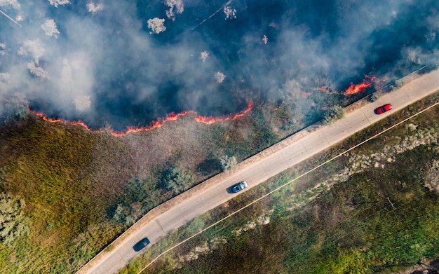 Vista superior no início do incêndio em um campo gramado perto da estrada