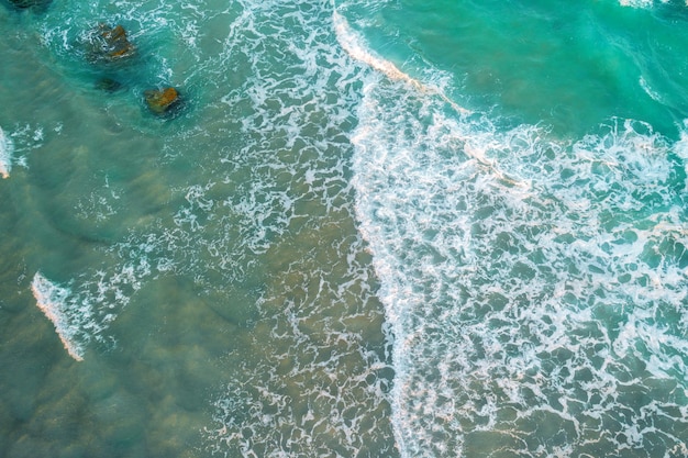 Foto vista superior de las olas del mar rodando en la playa