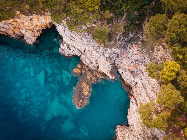 Vista superior de la orilla rocosa del mar Adriático cristalino, tiro de drone